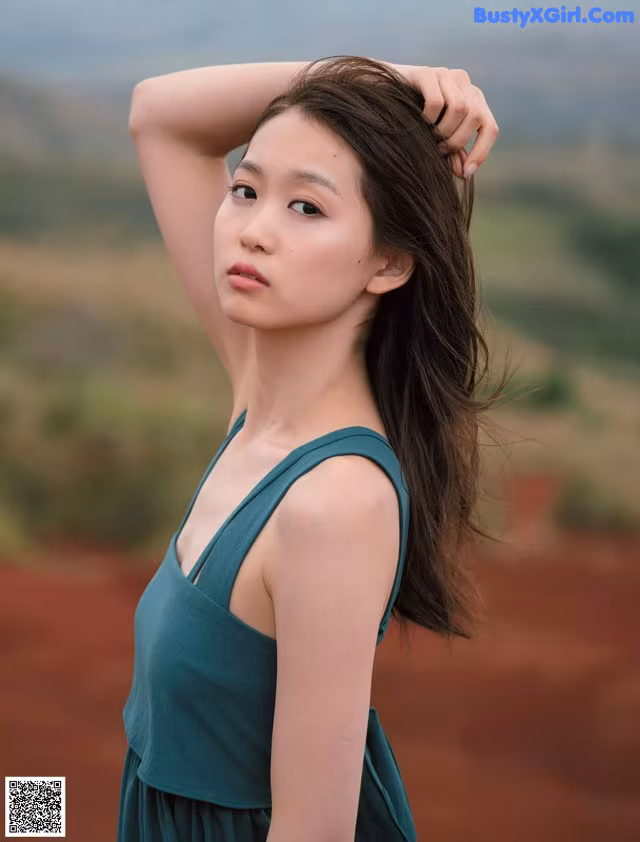 A woman in a green dress posing for a magazine.