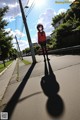 A woman in a red sweater is walking down the street.