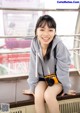 A young woman sitting on a bench with a camera.