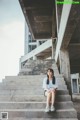 A woman sitting on the steps of an abandoned building.