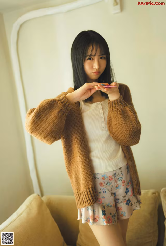 A woman standing in front of a mirror holding a cell phone.