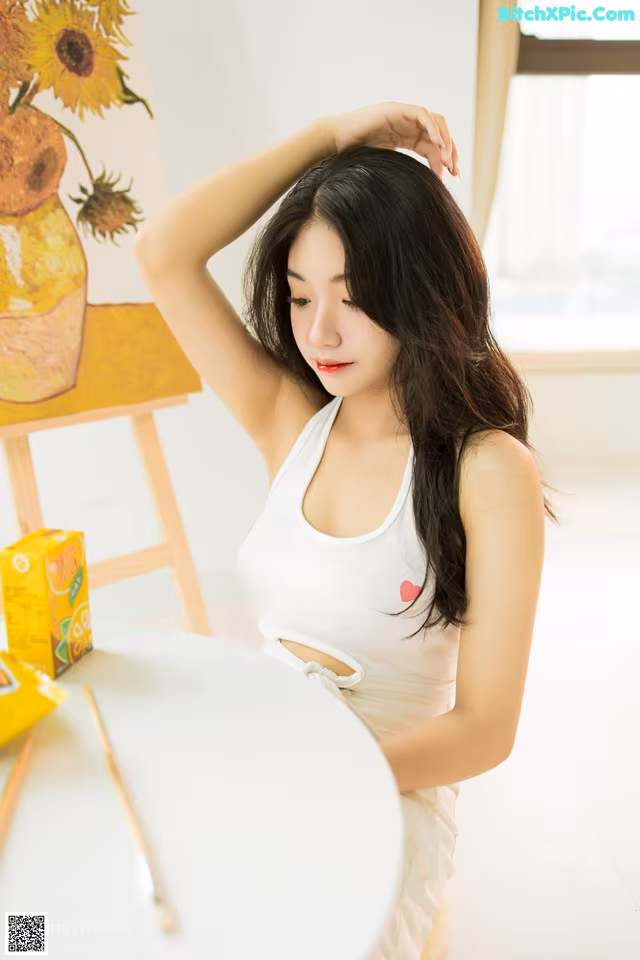 A woman sitting at a table with a box of juice.
